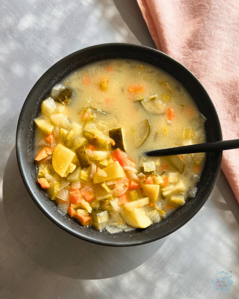 slow cooker creamy pickle soup in a bowl with a spoon