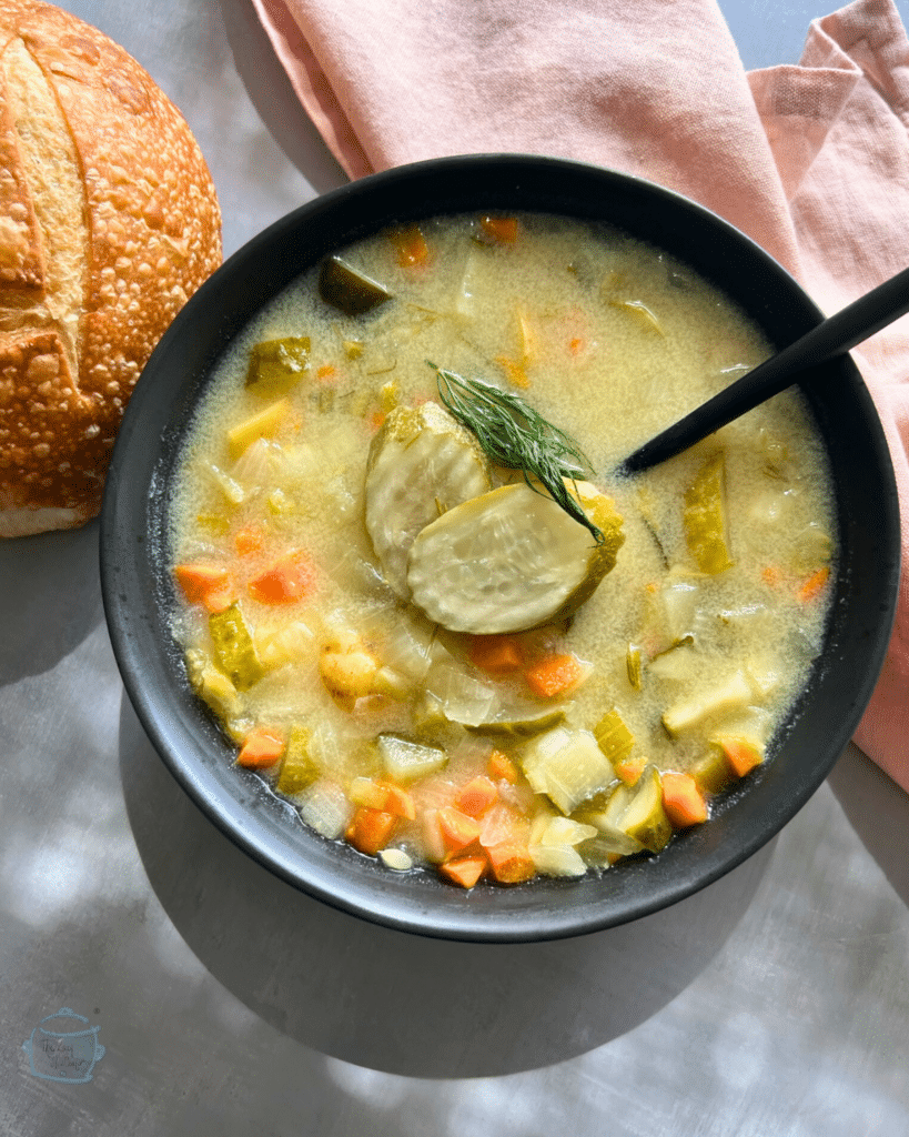 slow cooker creamy pickle soup in a bowl with a spoon