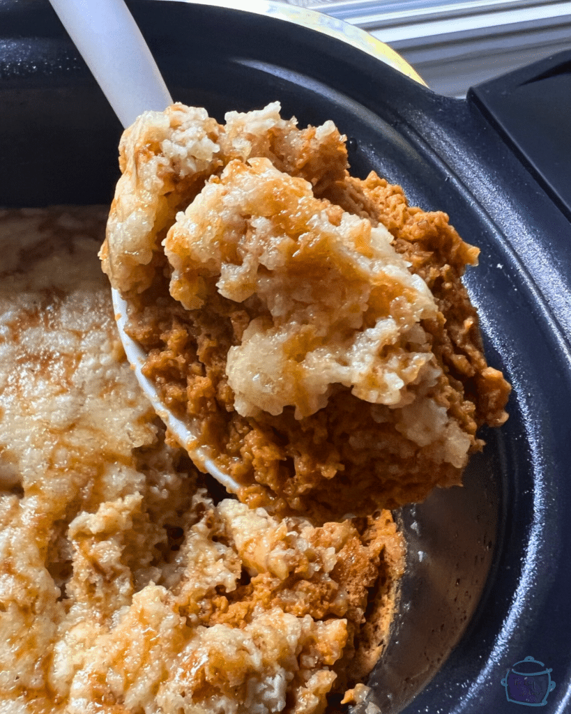 finished pumpkin cobbler in a slow cooker with a spoonful of the same