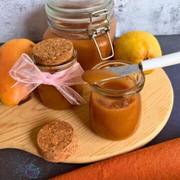 decorative jars filled with salted caramel pear butter on a cutting board