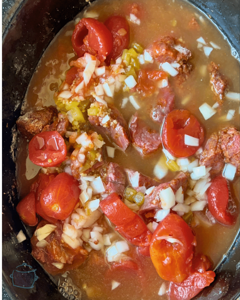 uncooked carne guisada ingredients in a slow cooker