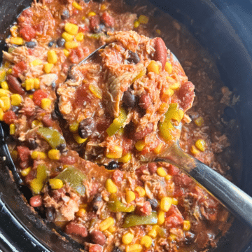 a ladle full of cooked leftover turkey chili held over a crockpot full of the same