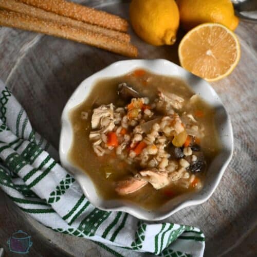 a white bowl filled with soup, mushrooms, veggies and barley