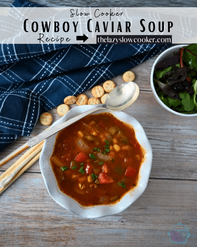 A bowl of slow cooker cowboy soup with a spoon and crackers off to the side