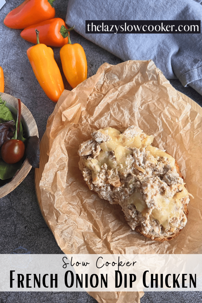 an open faced french onion slow cooker chicken sandwich on parchment paper