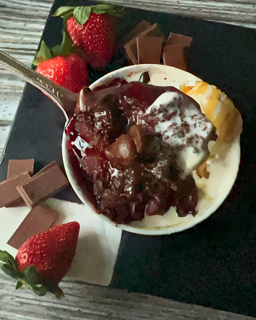 a spoonful of chocolate strawberry brownie held over a bowl full of the same