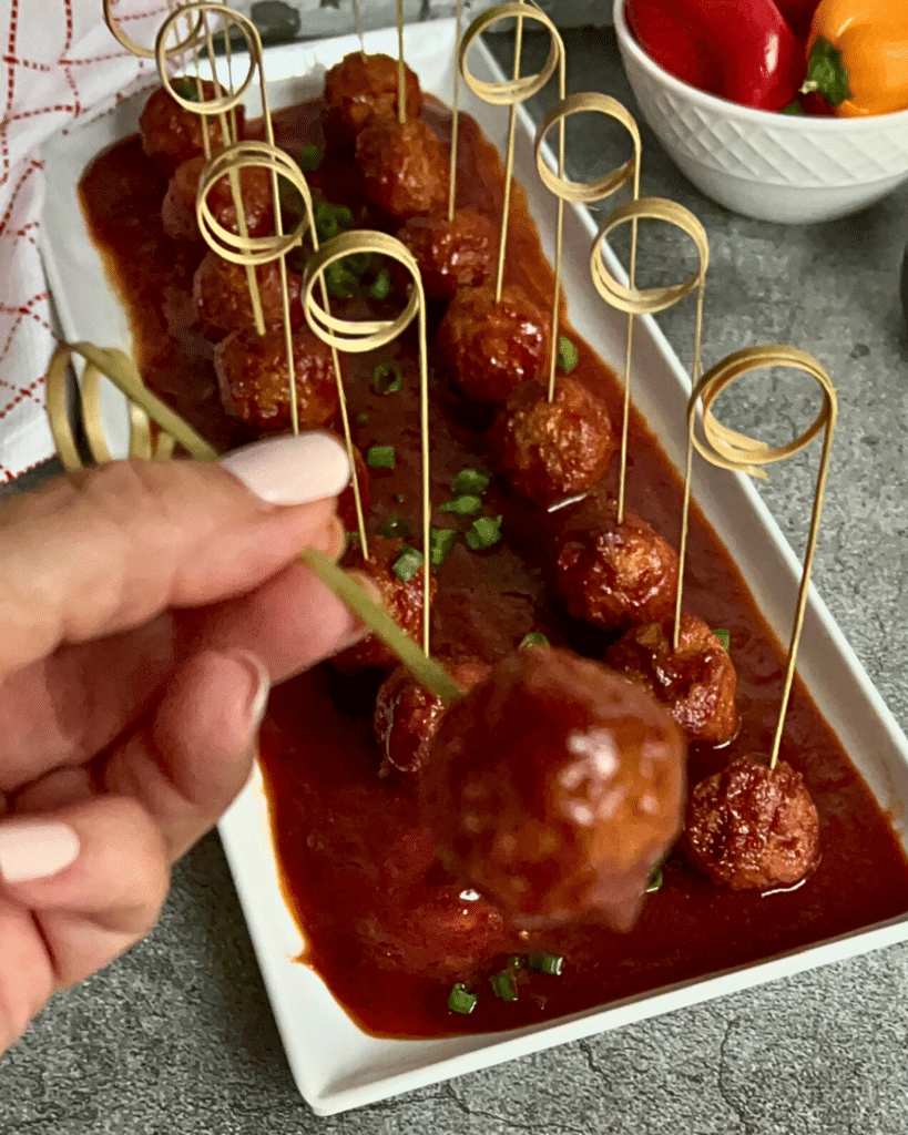 Guinness glazed meatballs on a tray with decorative picks for appetizers 