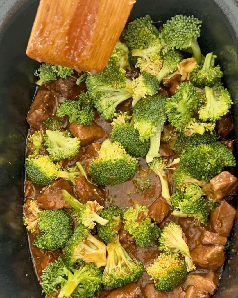 raw broccoli added on top of cooked orange beef in crockpot