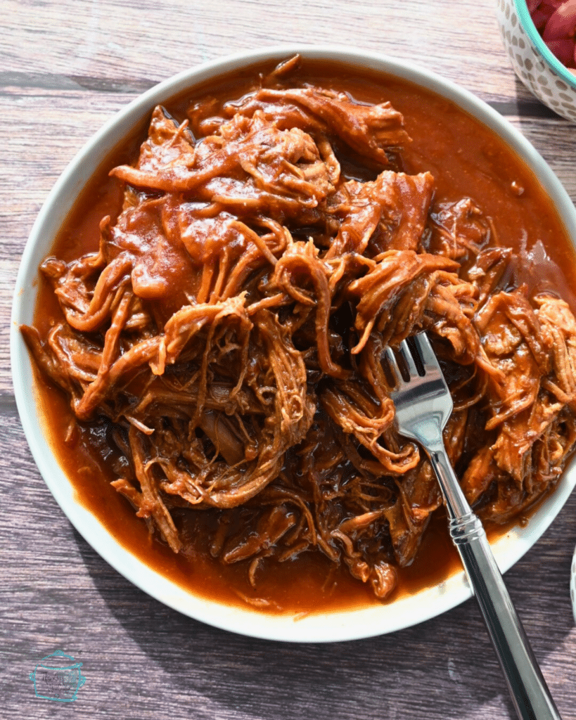 shredded slow cooker brisket on a white round plate