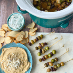 slow cooker warm olives on toothpicks on an appetizer sample board
