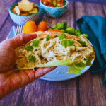 lemon Tahini chicken on a bed of lettuce held by a hand