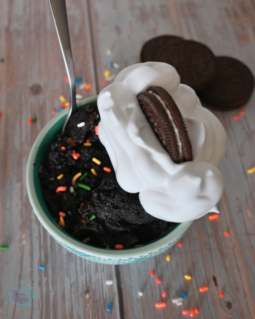 1 bowl of oreo mug cake with whipped cream, sprinkles, and half and oreo on top