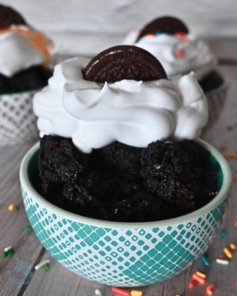 three bowls of oreo mug cake each with a different topping and half and oreo on top