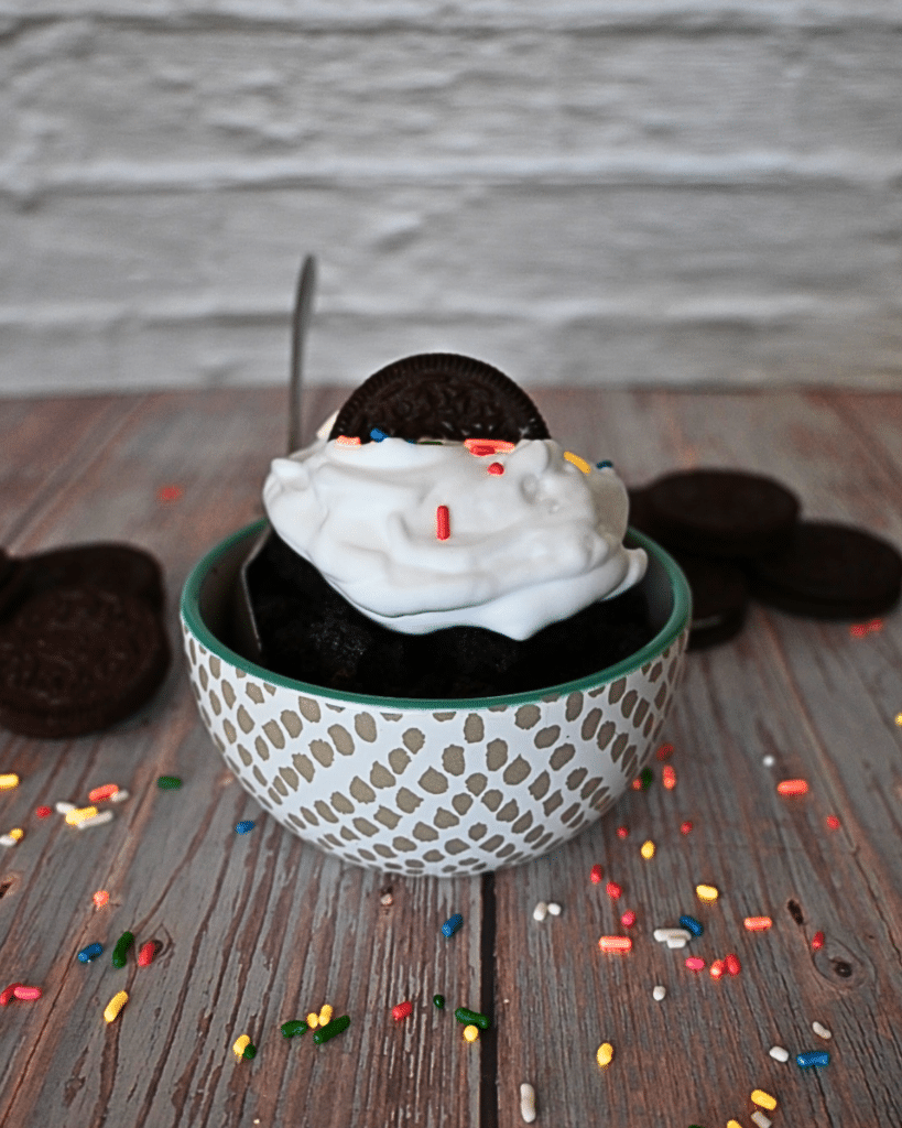 1 bowl of oreo mug cake with whipped cream, sprinkles, and half and oreo on top