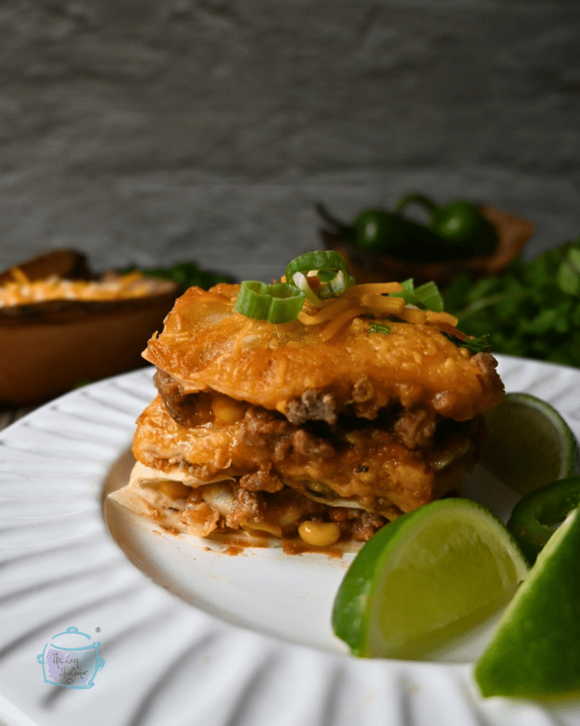 a slice of tortilla lasagna on a round white plate