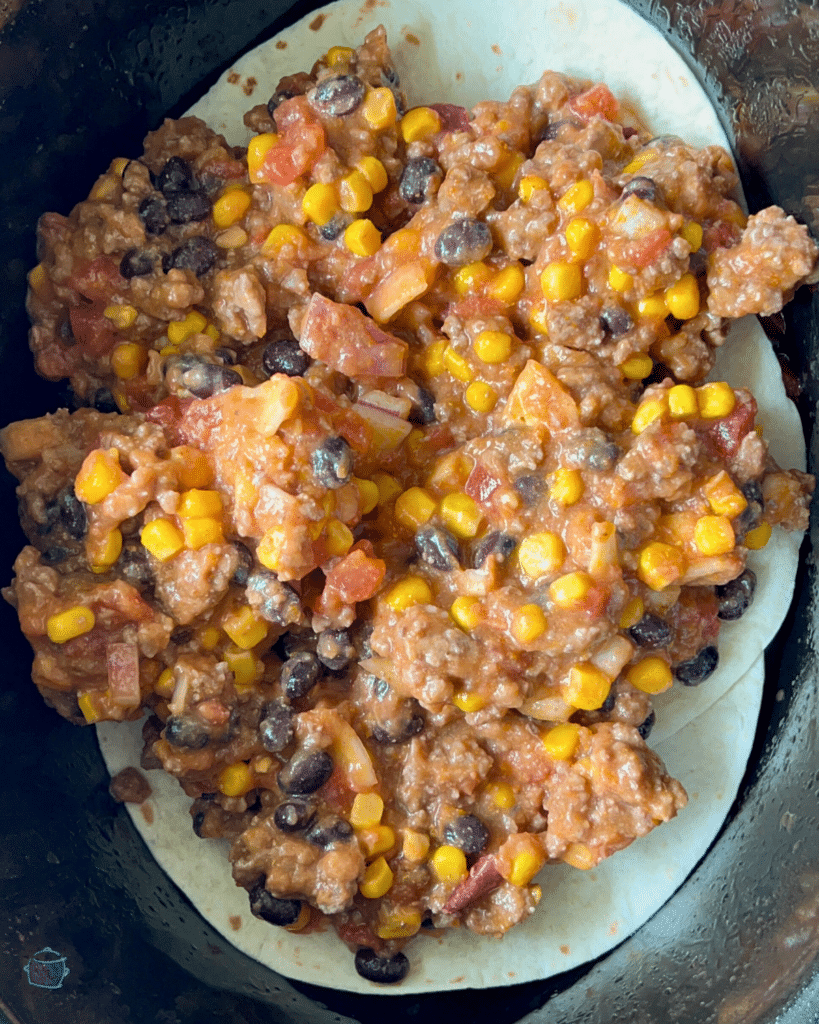 layering meat mixture over tortillas