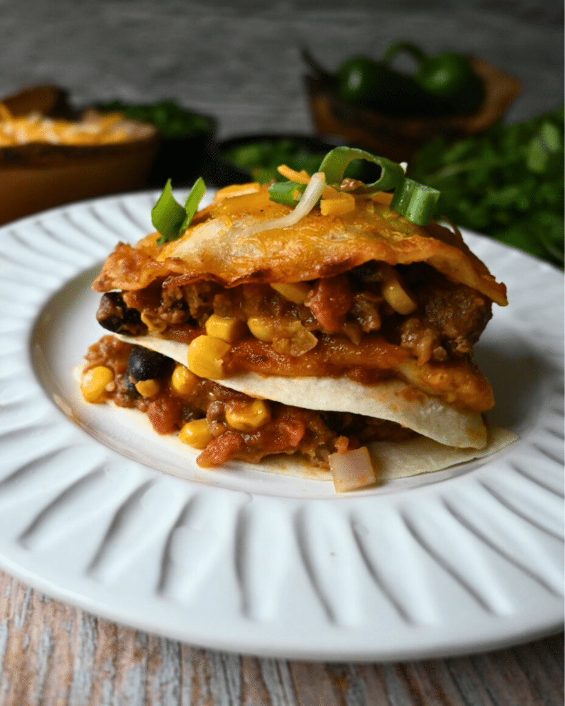 a slice of tortilla lasagna on a round white plate