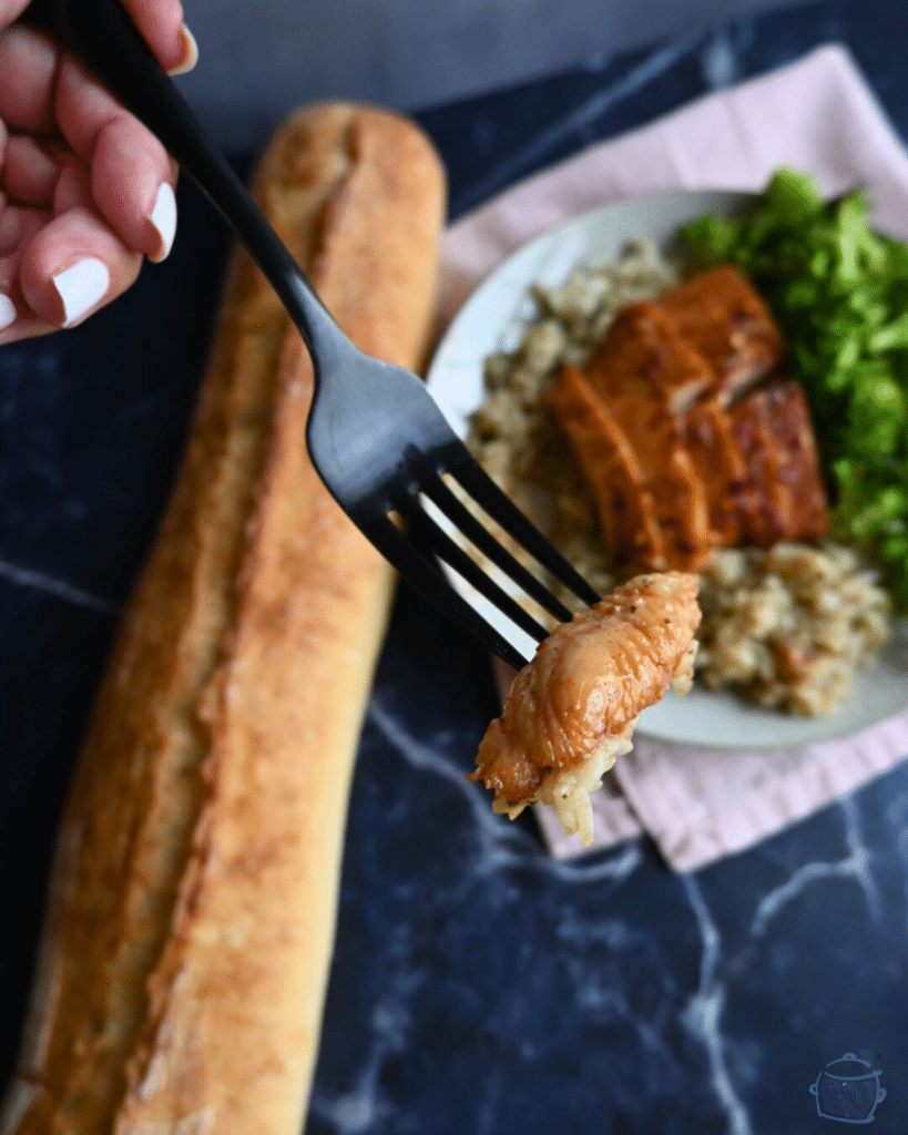 Hot honey glazed slow cooker turkey tenderloin slice on a fork over a plate of the same