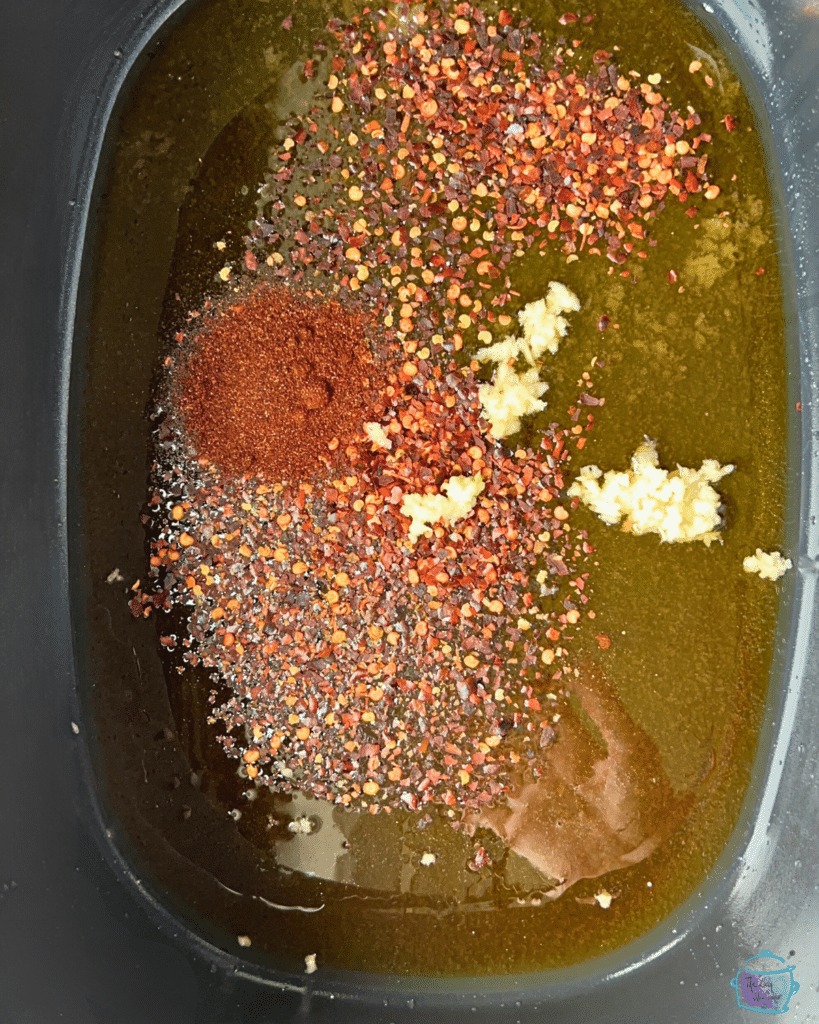 hot honey sauce ingredients in a crockpot before stirring togehter