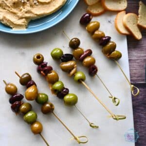 slow cooker warm olives on toothpicks on an appetizer sample board