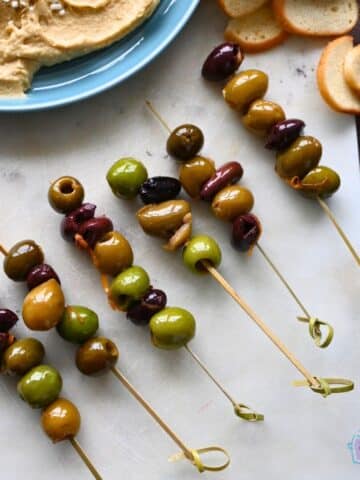 slow cooker warm olives on toothpicks on an appetizer sample board