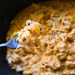 buffalo chicken ramen in a slow cooker after cooking with some held on a fork