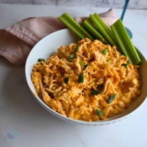 chicken buffalo ramen in a bowl ready to serve with celery stalks on the side