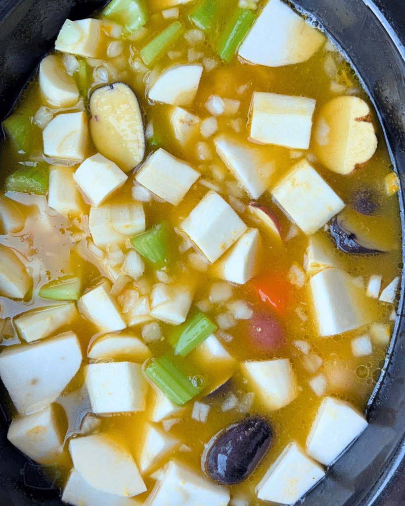 root veggies and seasonings and broth in a slow cooker before cooking