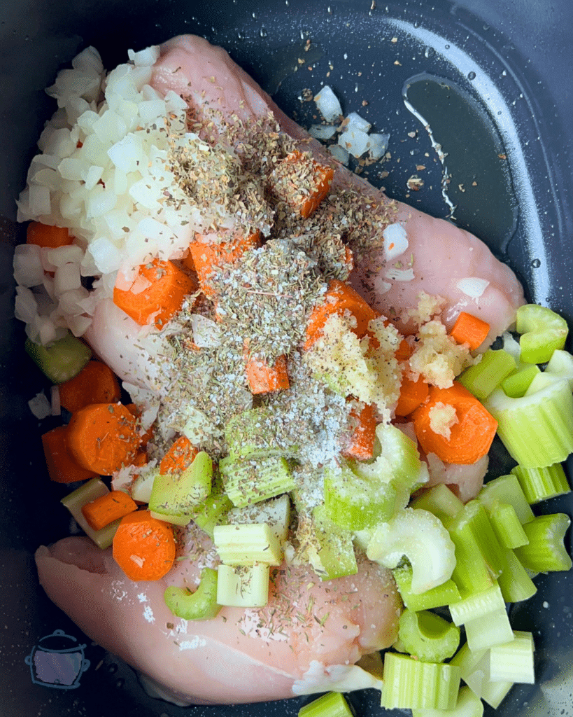chicken, veggies and spices in a slow cooker before adding luquids