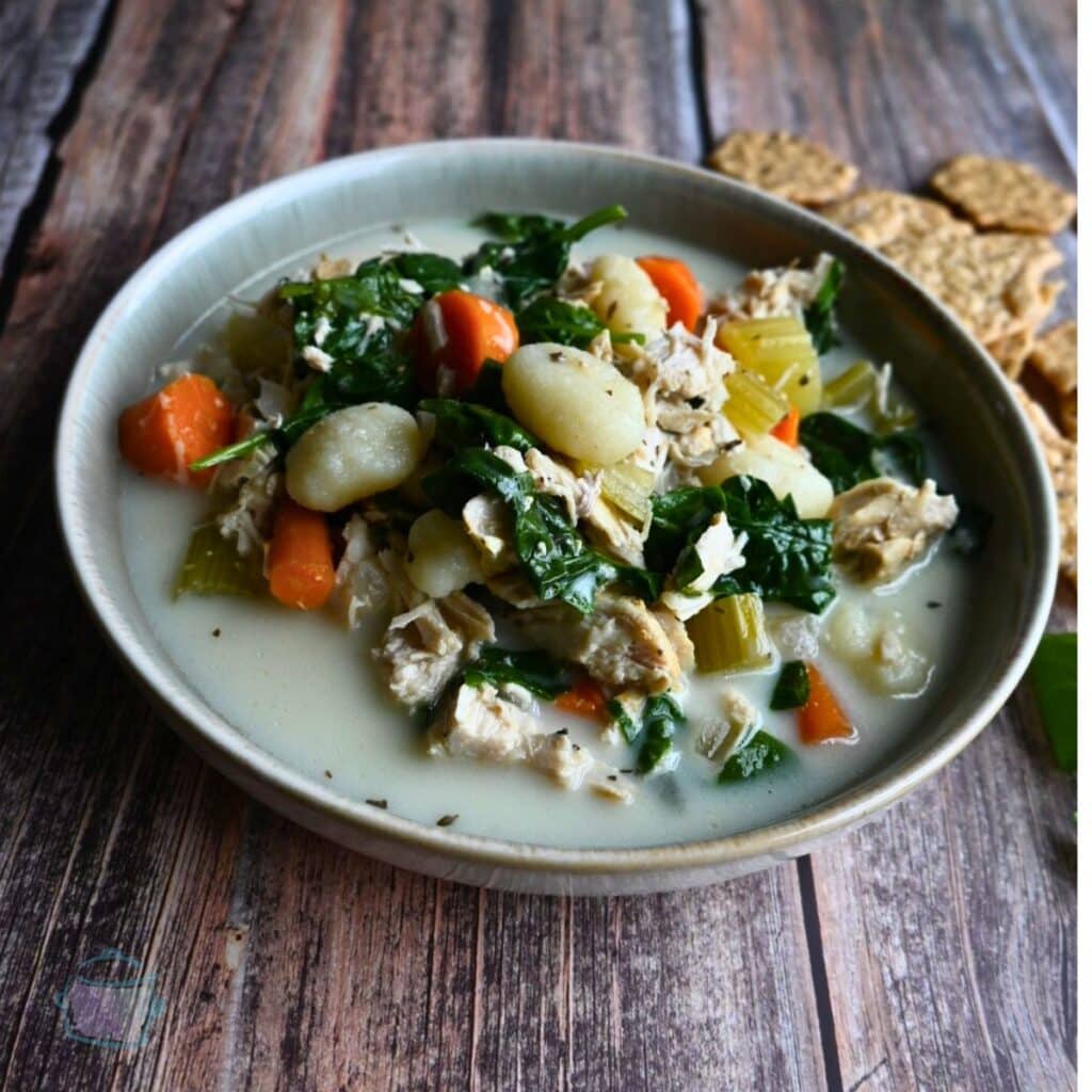 slow cooker chicken gnocchi soup in a round gray bowl