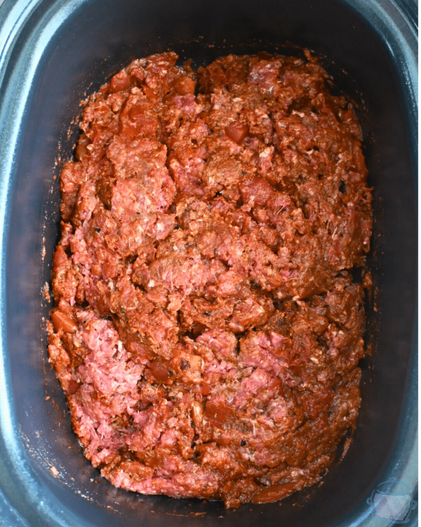 all taco meat ingredients stirred together in slow cooker before cooking