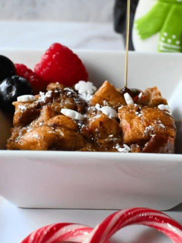 slow cooker bread pudding with sauce being poured on top