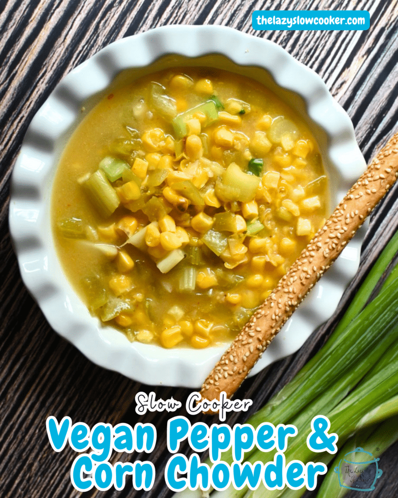 vegan corn chowder in white bowl with a bread stick on the side