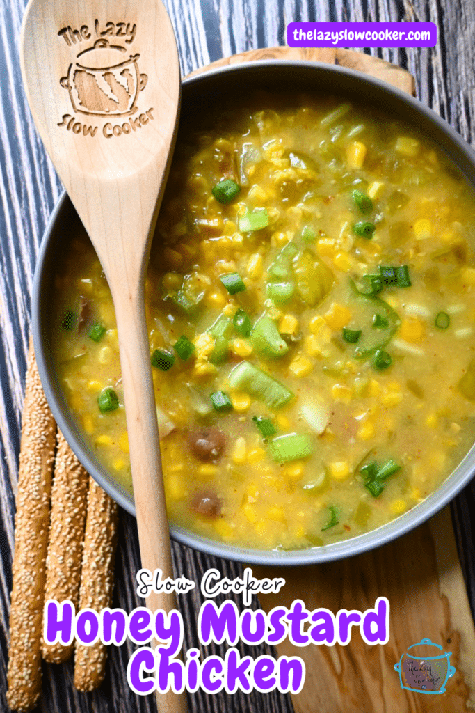 pepper and corn chowder in a round gray bowl with a wooden spoon.