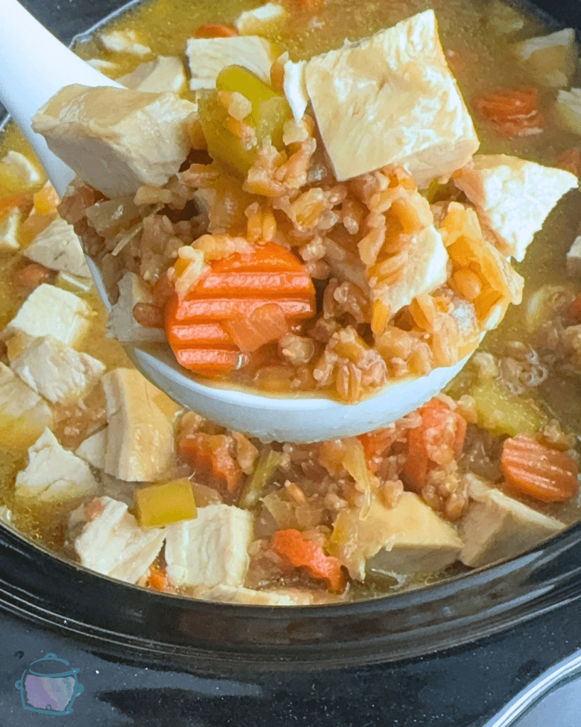 turkey miso farro soup on a ladle held over a crockpot full of the same