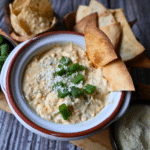 a bowl filled with slow cooker corn dip and chips