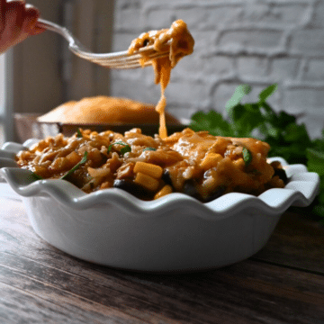 slow cooker chicken stew on a fork over a bowl of the same