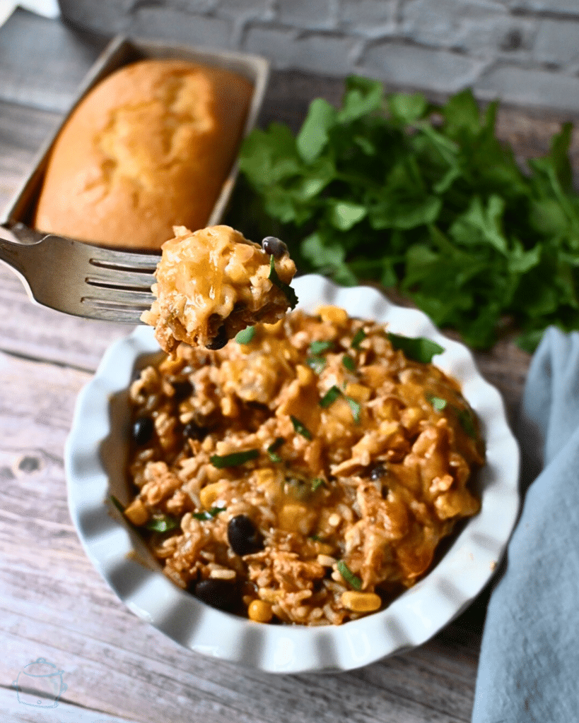 slow cooker southwest chicken casserole in a round white bowl with a fork