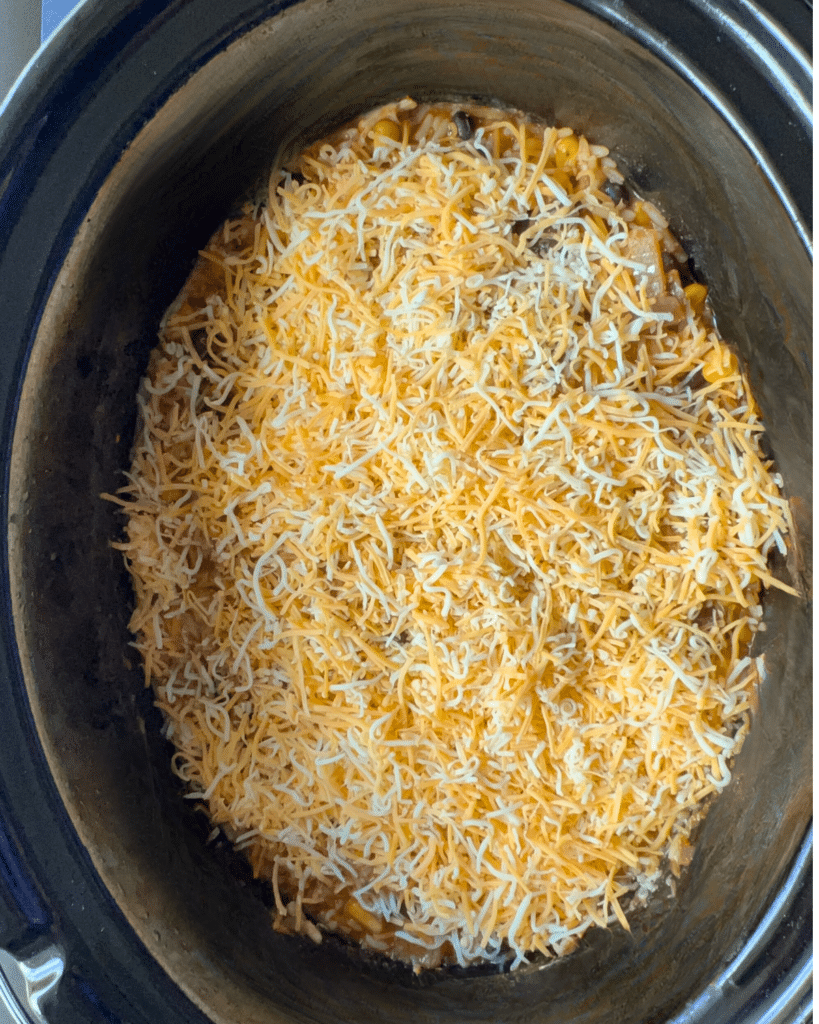 topping cooked chicken casserole with cheese
