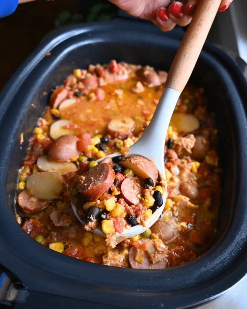 texas cowboy stew held on a spoon over a slow cooker full of the same