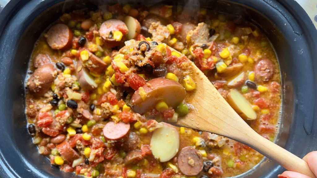 texas cowboy stew held on a spoon over a slow cooker full of the same