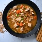 a black bowl filled with turkey farro miso soup