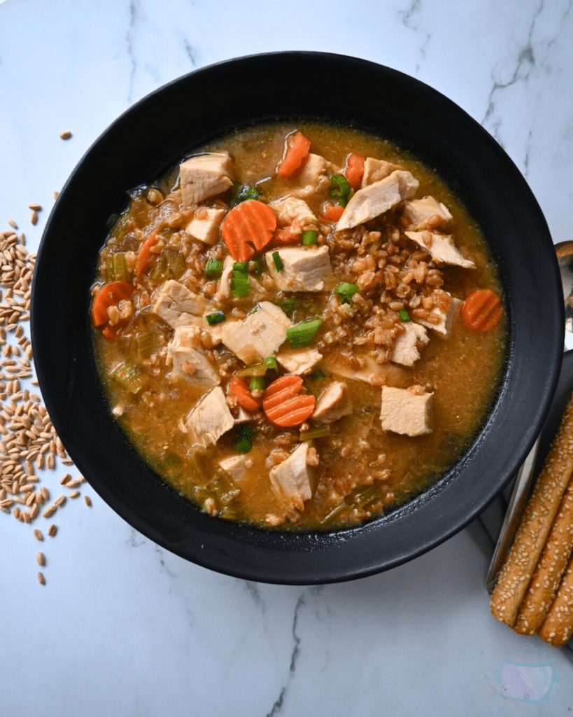 a black bowl filled with turkey farro miso soup
