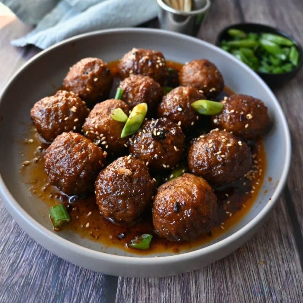 a bowl full of slow cooker spicy maple meatballs ready to serve