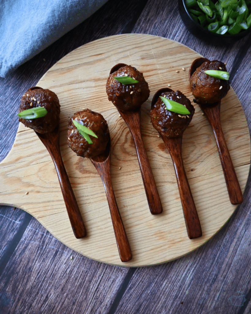 spicy maple meatballs on wooden appetizer spoon