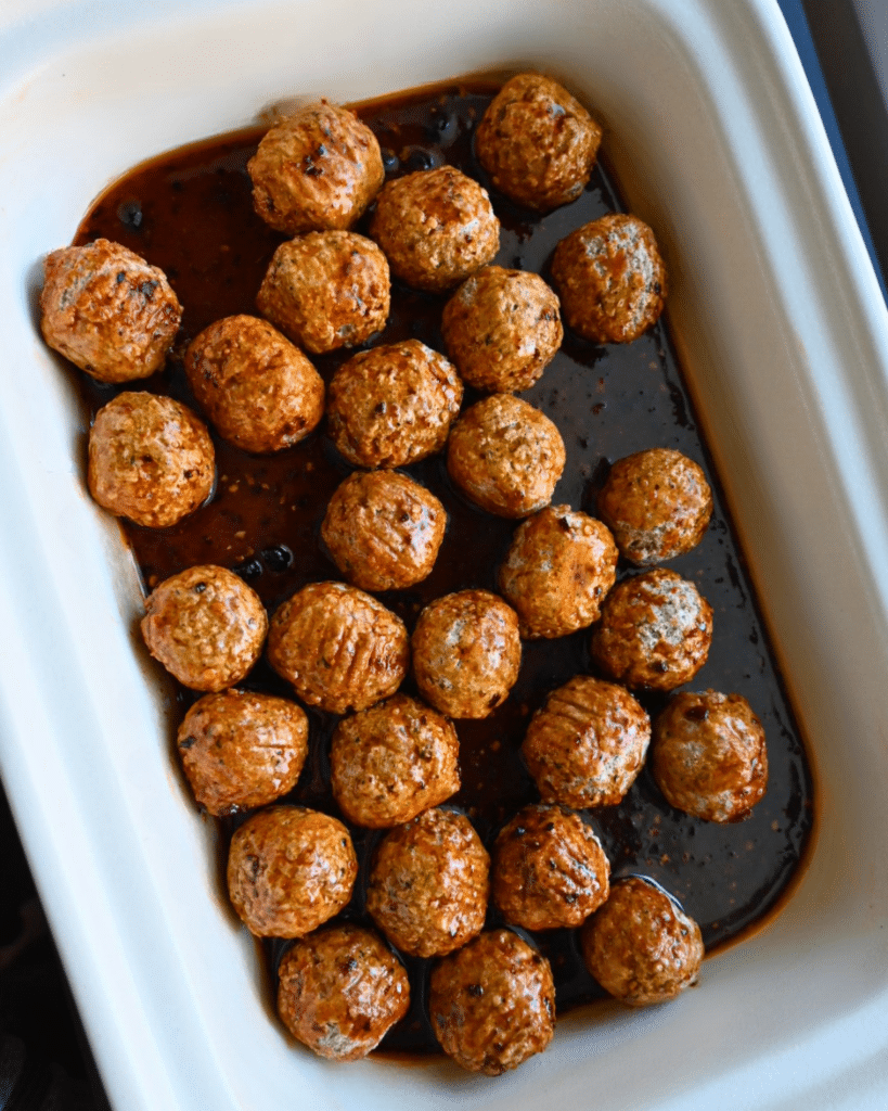 a slow cooker full of hot-maple meatballs