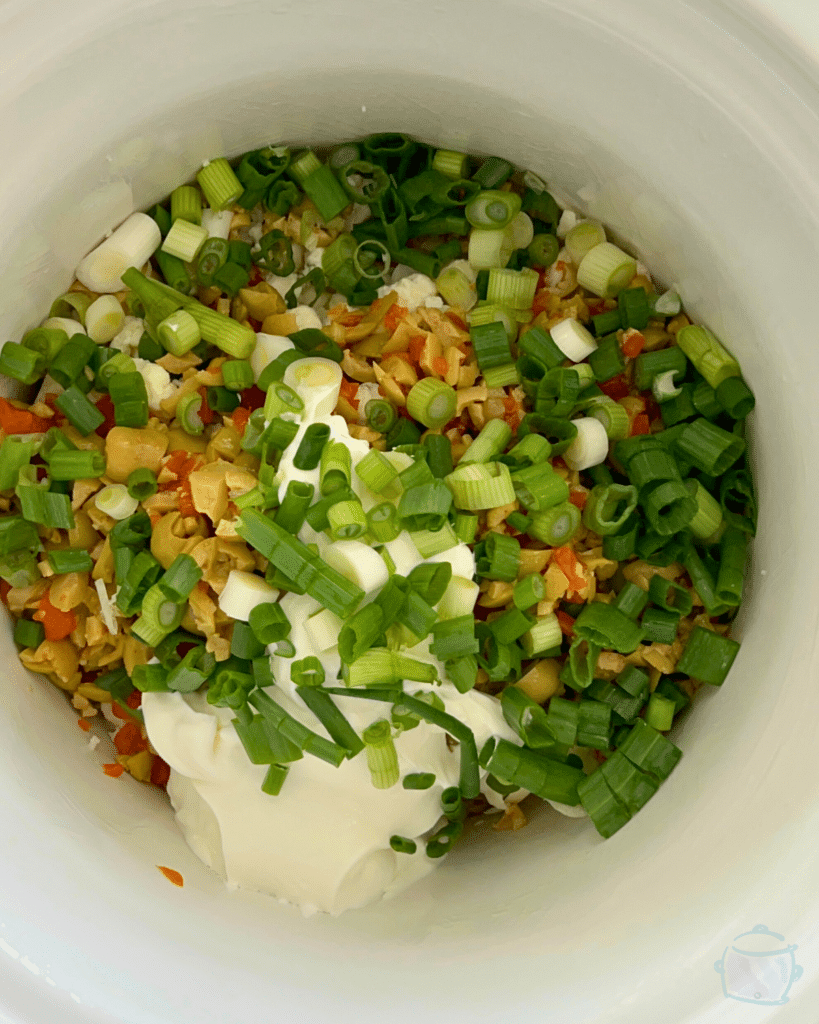 dirty martini dip ingredients in slow cooker before cooking 
