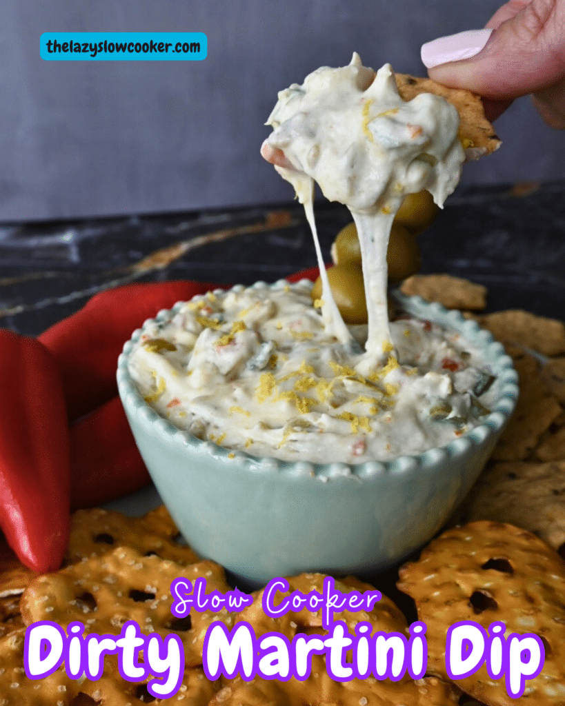 slow cooker dirty martini dip on a cracker over a bowl of the same
