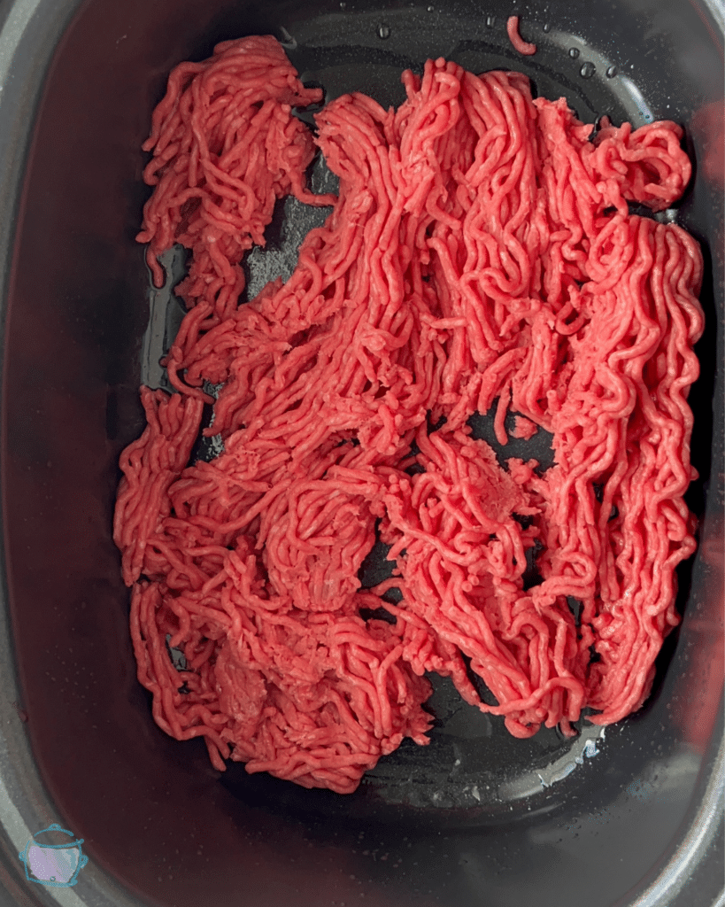 uncooked ground beef in a slow cooker