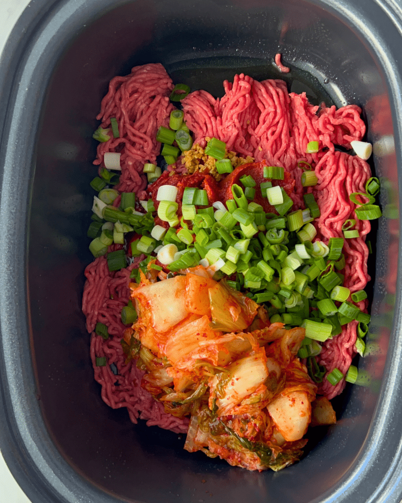 sloppy kimchi joe ingredients in a crock pot before cooking